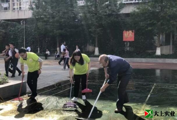 王炳林帶領(lǐng)大家清洗塑膠球場(chǎng)的場(chǎng)景