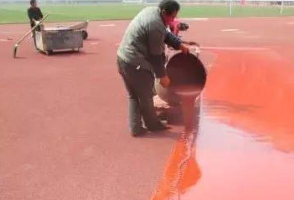 將攪拌好的塑膠跑道材料倒入施工區(qū)域